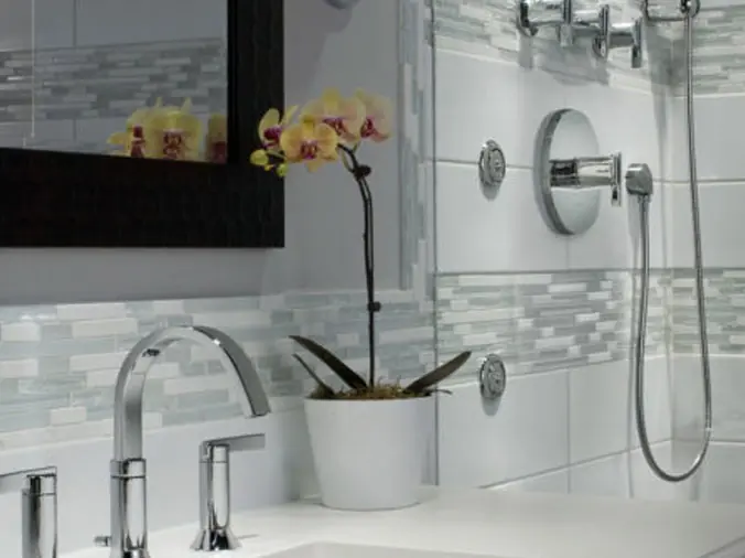 white tile bathroom with brushed stainless sink and shower fixtures