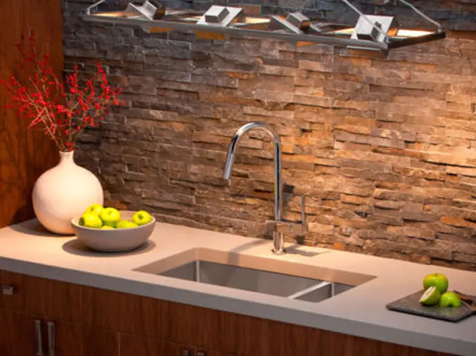 gooseneck kitchen sink with stone backsplash