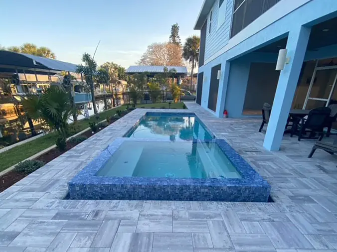Rectangular swimming pool with attached hot tub