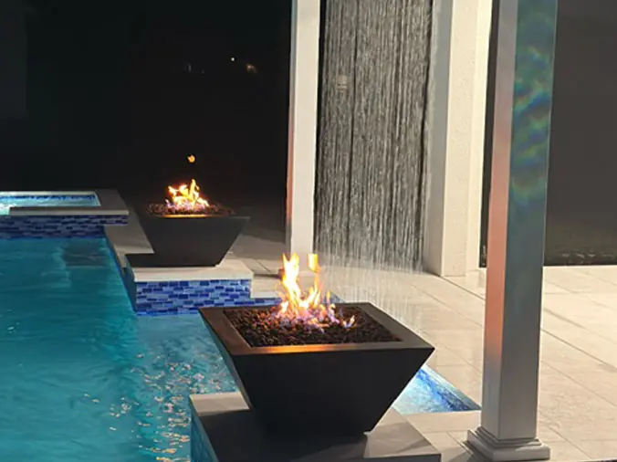 Pool with decorative fire pots and water wall