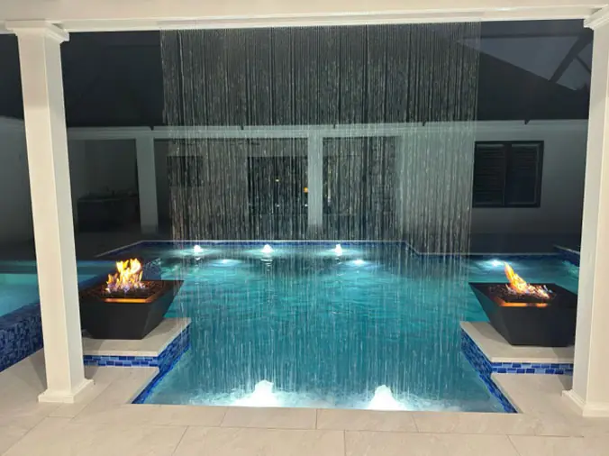 Swimming poll at night with lights and water wall