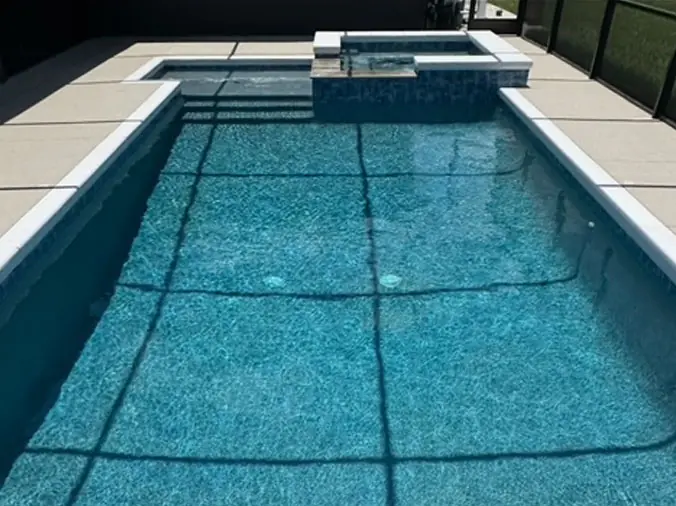 Rectangular swimming pool with attached corner hot tub