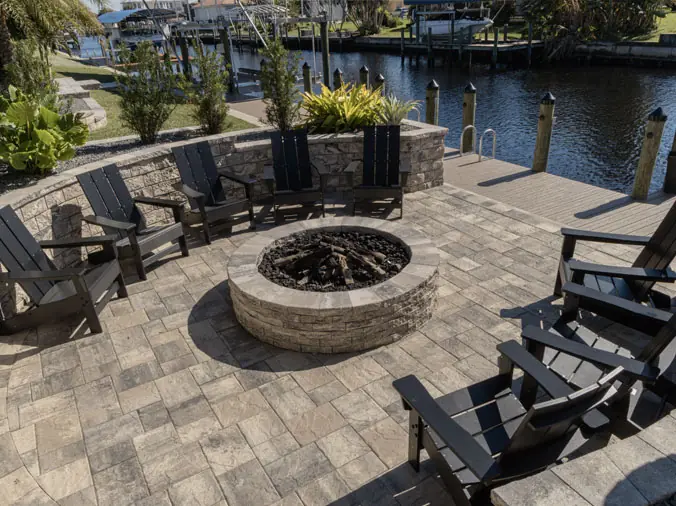 Stone paver firepit area with chairs next to the bay